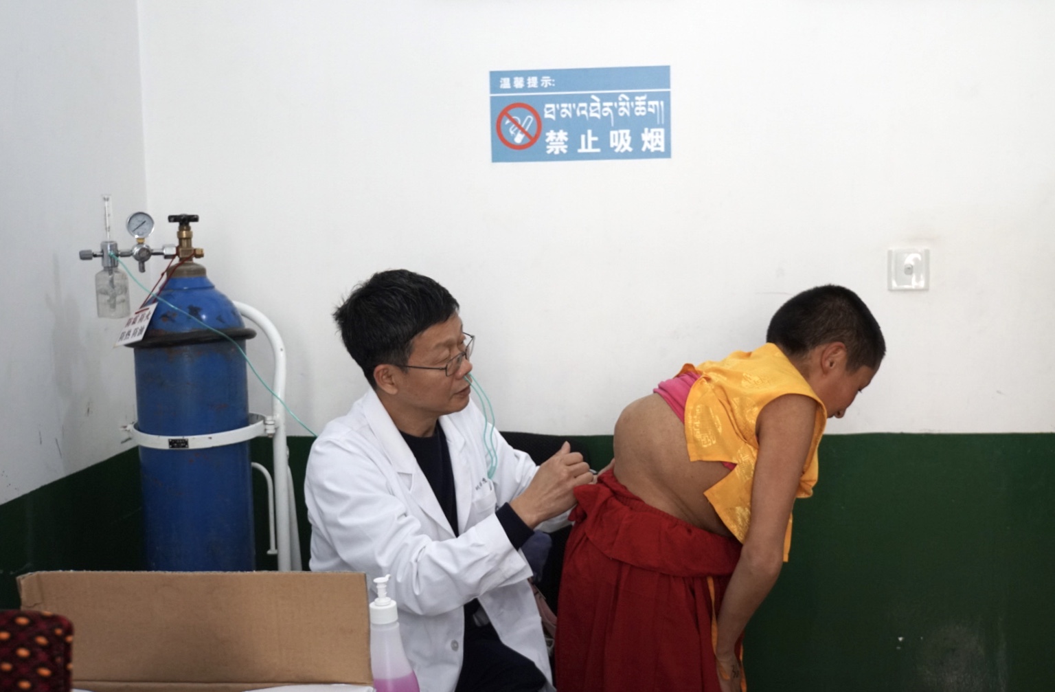3.刘海鹰吸着氧为西藏患者义诊。（图片由北京大学人民医院提供）.jpg