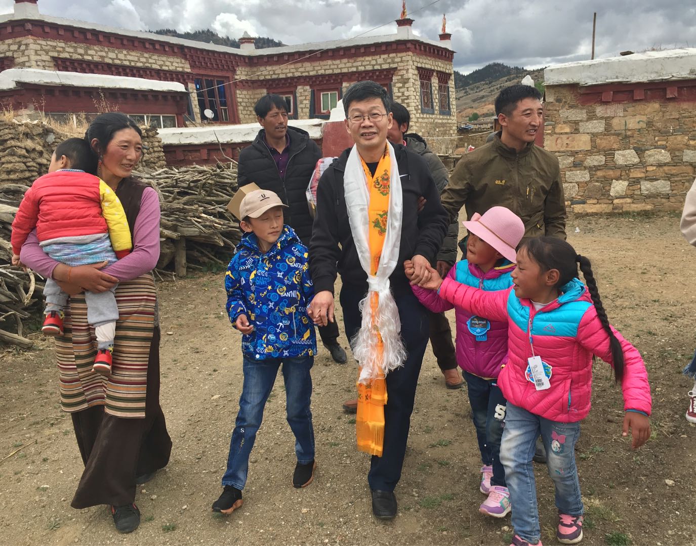 7.2017年9月12日，刘海鹰赴四川理塘患儿泽仁拥忠（前排右一）家中，看望她术后恢复情况。（图片由北京大学人民医院提供）.jpg